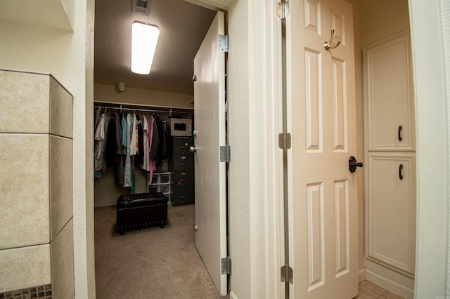 walk in closet featuring light carpet