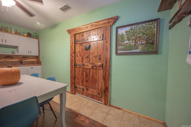 tiled dining space with ceiling fan