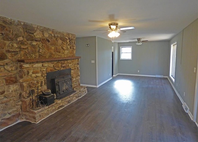 unfurnished living room featuring ceiling fan, dark wood-type flooring, and a fireplace