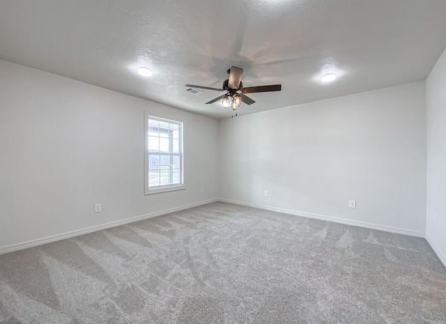 empty room with carpet flooring, ceiling fan, and a textured ceiling