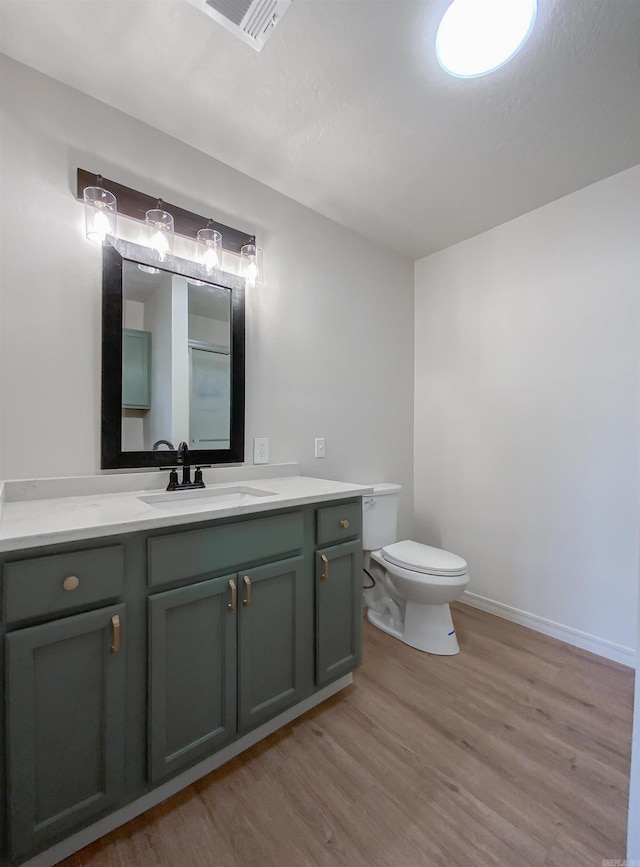 bathroom featuring vanity, toilet, and wood-type flooring