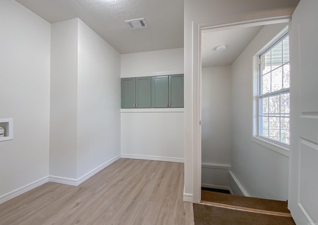 interior space featuring a textured ceiling and light wood-type flooring