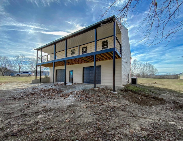 back of house with cooling unit and a garage