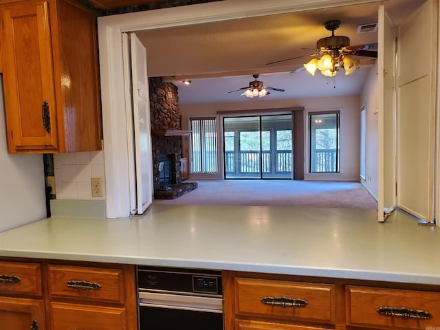 kitchen with a fireplace, backsplash, and ceiling fan