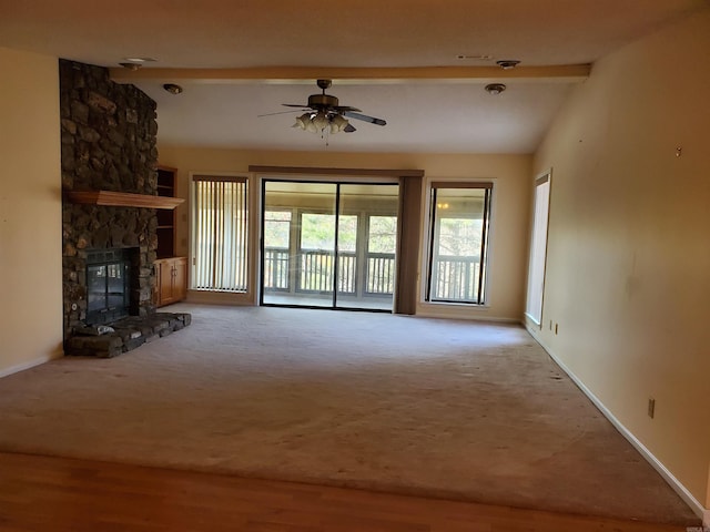 unfurnished living room with vaulted ceiling with beams, ceiling fan, light colored carpet, and a fireplace