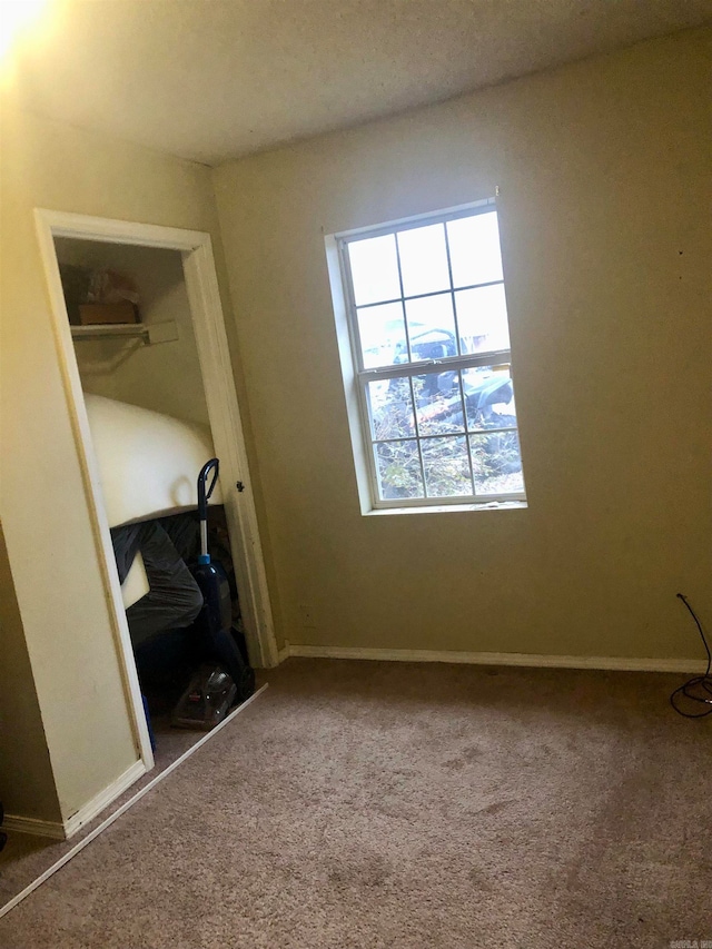 unfurnished bedroom with a closet, a textured ceiling, and carpet floors