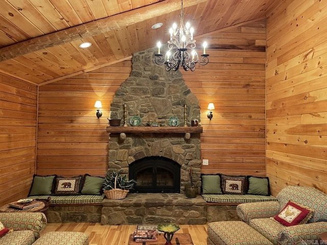 living room featuring an inviting chandelier, lofted ceiling with beams, a stone fireplace, hardwood / wood-style flooring, and wood ceiling
