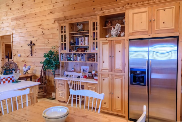kitchen featuring stainless steel refrigerator with ice dispenser, wooden walls, and light hardwood / wood-style flooring