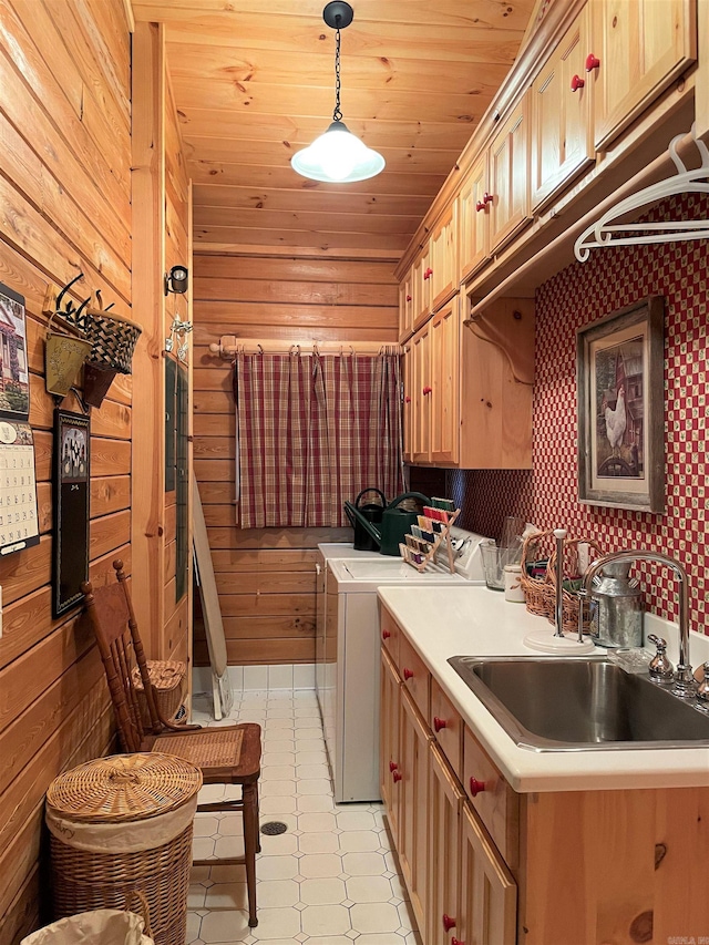 laundry area featuring cabinets, sink, separate washer and dryer, wooden ceiling, and wood walls