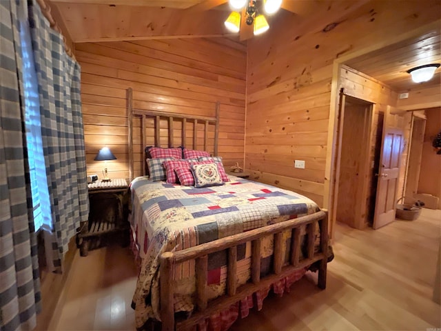 bedroom featuring wood ceiling, vaulted ceiling, ceiling fan, wooden walls, and wood-type flooring