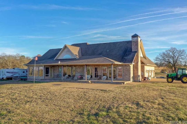 rear view of house with a lawn and a patio area