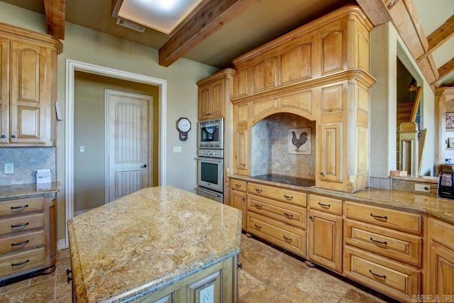 kitchen with backsplash, appliances with stainless steel finishes, light stone counters, a kitchen island, and beam ceiling