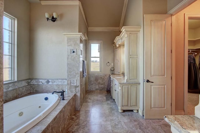 bathroom with tiled tub, crown molding, and vanity