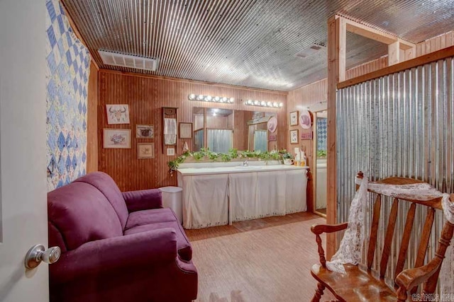 living area featuring wood walls, wood-type flooring, and sink