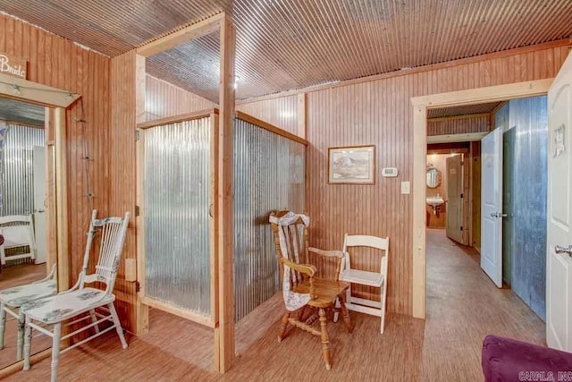 sitting room featuring light wood-type flooring and wood walls