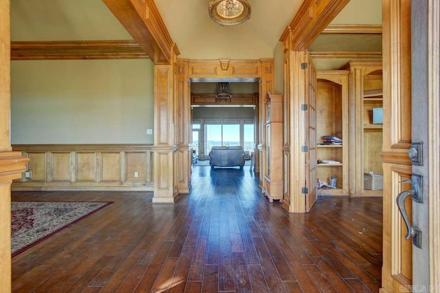 foyer entrance featuring decorative columns, dark hardwood / wood-style floors, and ornamental molding