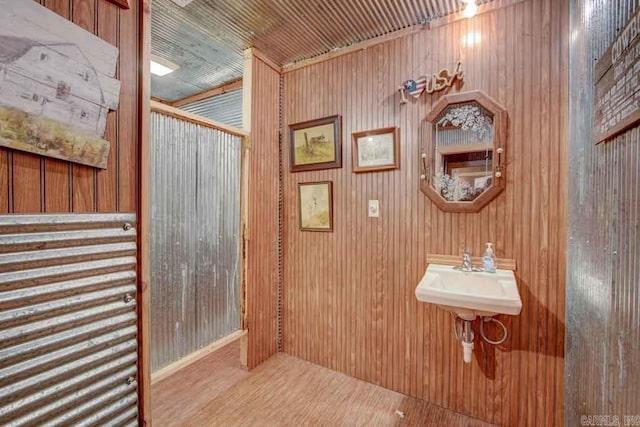 bathroom featuring wood walls, hardwood / wood-style flooring, and sink