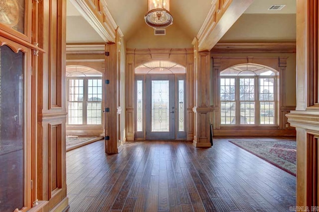 foyer entrance with ornamental molding, dark hardwood / wood-style floors, and high vaulted ceiling