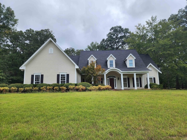 cape cod home featuring a front lawn