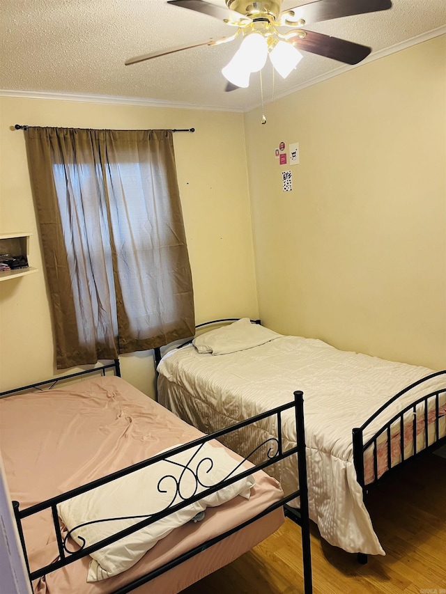 bedroom with crown molding, a textured ceiling, a ceiling fan, and wood finished floors