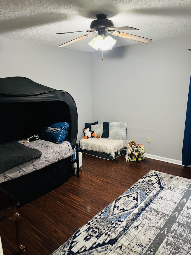 bedroom featuring ceiling fan, a textured ceiling, and wood finished floors