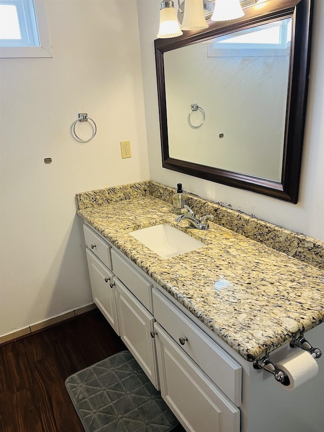 bathroom featuring baseboards, wood finished floors, and vanity