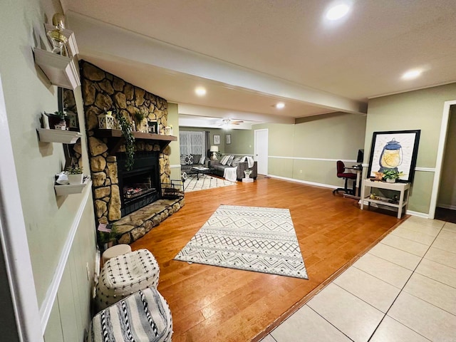 living room featuring ceiling fan, a fireplace, and hardwood / wood-style floors