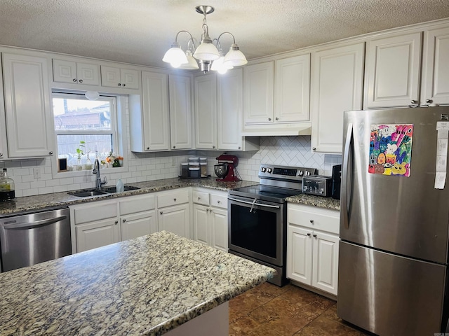 kitchen featuring stainless steel appliances, a sink, white cabinets, and under cabinet range hood