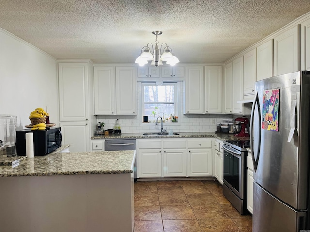 kitchen with appliances with stainless steel finishes, white cabinets, a sink, and tasteful backsplash