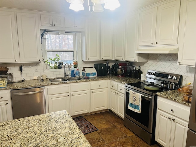 kitchen with under cabinet range hood, a sink, white cabinets, appliances with stainless steel finishes, and backsplash
