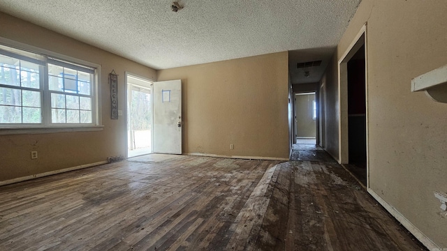 10085 James Dr, Havana, AR 72842 - empty room featuring a textured ceiling and dark wood-type flooring