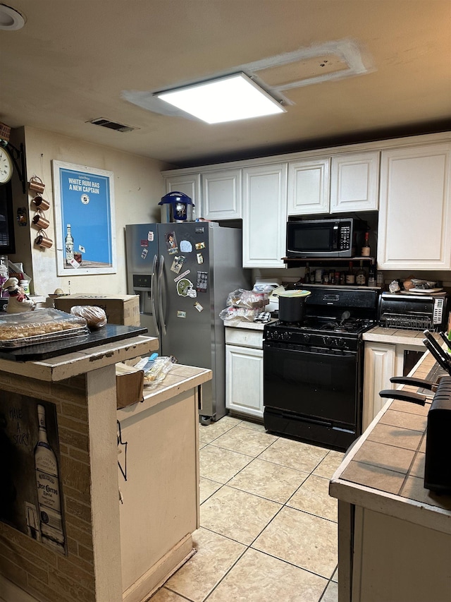 kitchen featuring black gas range oven, light tile patterned floors, white cabinetry, stainless steel refrigerator with ice dispenser, and tile counters