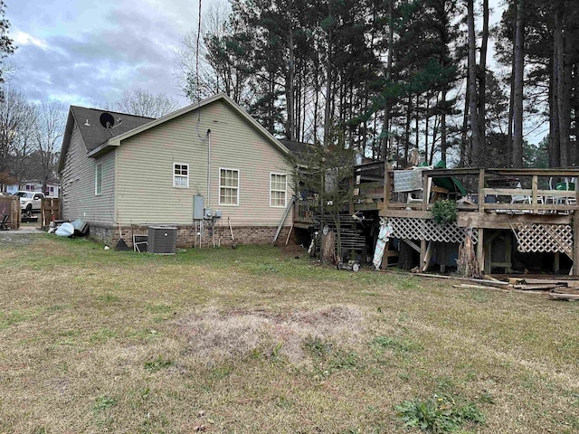 back of property with cooling unit, a lawn, and a deck