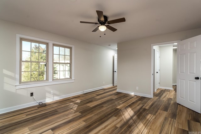 unfurnished room with ceiling fan and dark wood-type flooring