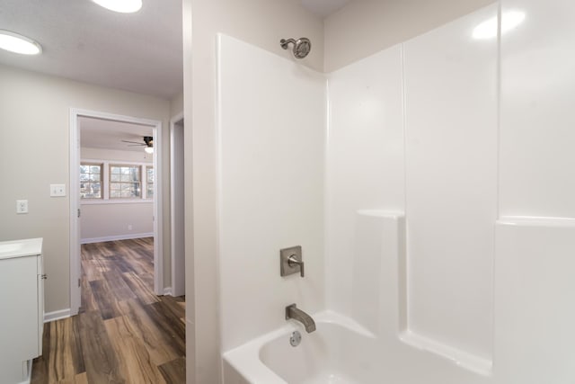 bathroom with ceiling fan, hardwood / wood-style floors, vanity, and bathing tub / shower combination