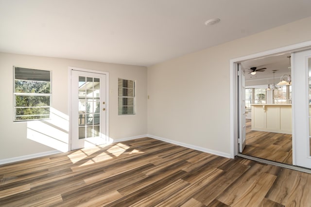 empty room with a healthy amount of sunlight and dark hardwood / wood-style flooring