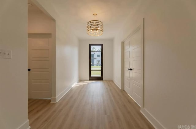 entryway featuring light hardwood / wood-style flooring and a chandelier