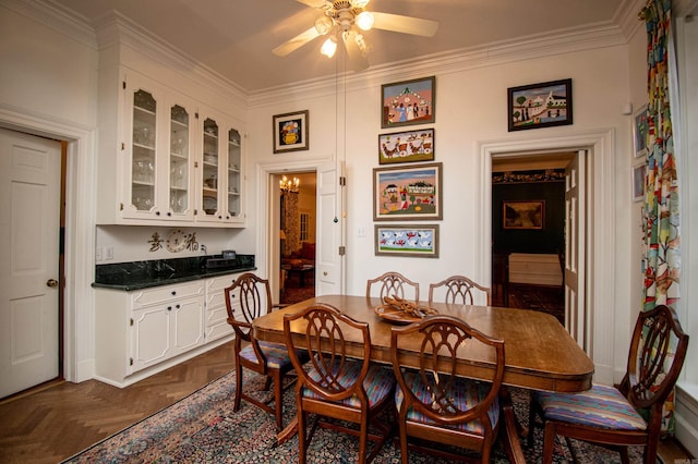 dining area with crown molding, dark parquet flooring, and ceiling fan