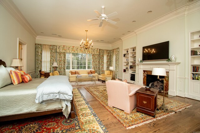 bedroom with ornamental molding, ceiling fan with notable chandelier, and hardwood / wood-style floors