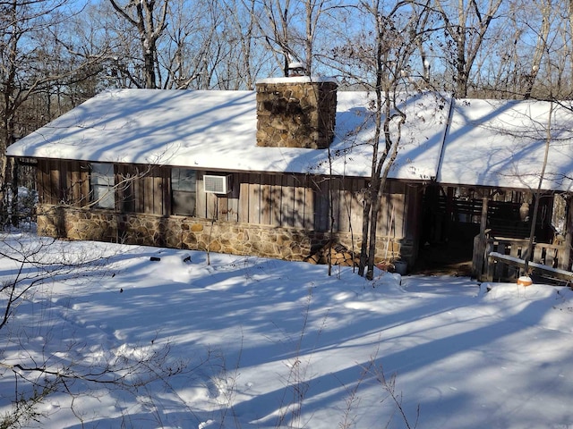 snow covered house with an AC wall unit