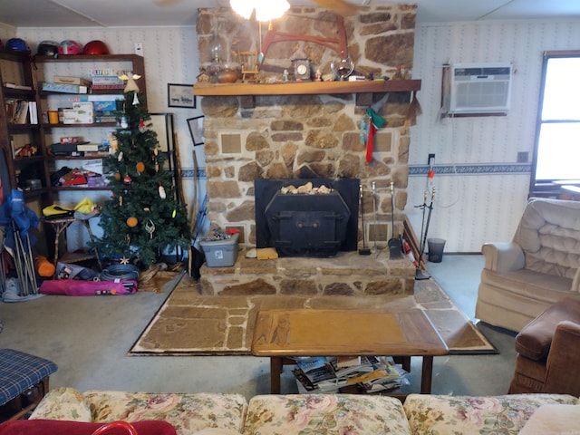 living room with a wall mounted AC, a wood stove, and a fireplace