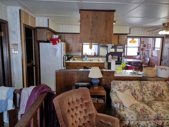 kitchen featuring ceiling fan, white refrigerator, and sink