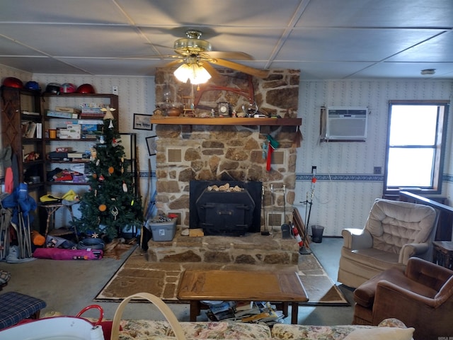 living room featuring ceiling fan, a fireplace, and a wall mounted AC