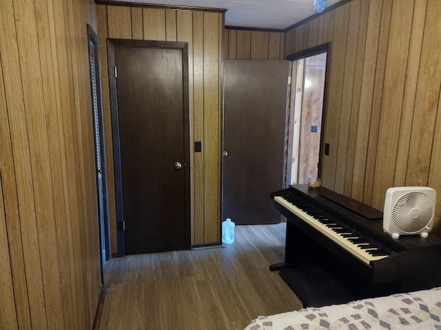 misc room with wooden walls, ornamental molding, and wood-type flooring