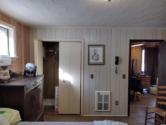 bedroom with dark hardwood / wood-style flooring, a closet, and wood walls