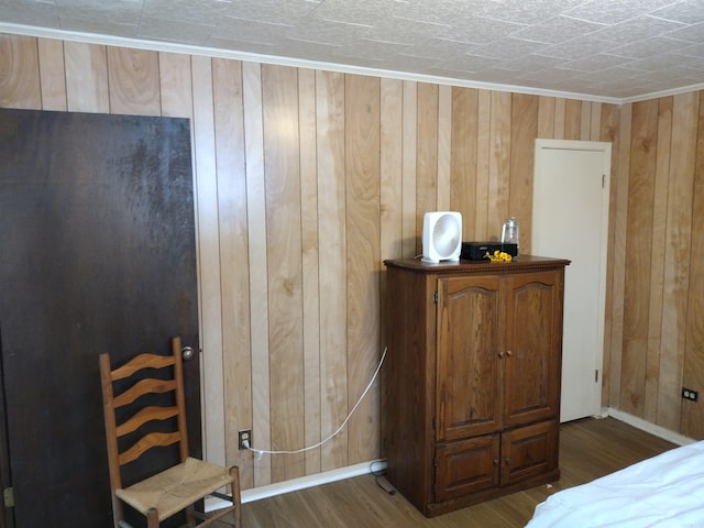 bedroom with wood walls and dark hardwood / wood-style floors