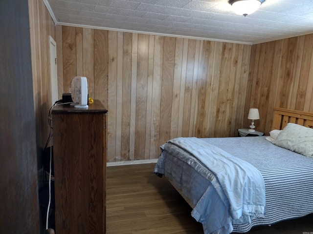 bedroom with wooden walls and dark hardwood / wood-style flooring