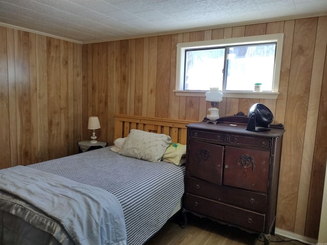 bedroom with wood walls and hardwood / wood-style floors