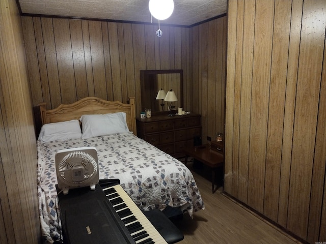 bedroom featuring wood walls and hardwood / wood-style floors