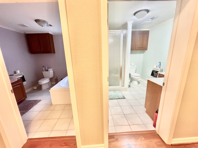 full bathroom with vanity, toilet, plus walk in shower, and tile floors